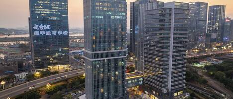 A high-rise building complex with multiple glass facades, a central courtyard, and surrounding roads.
