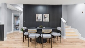 A dining area with a round table, six chairs, and two abstract paintings on the wall. - NEW Spacious and fun packed large home in Baltimore County (Reisterstown)