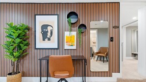 A room with a striped wall, a framed artwork, a potted plant, a chair, and a mirror. - NEW Spacious and fun packed large home in Baltimore County (Reisterstown)