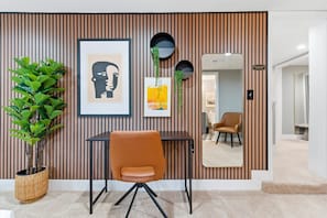 A room with a striped wall, a framed artwork, a potted plant, a chair, and a mirror. - NEW Spacious and fun packed large home in Baltimore County (Reisterstown)
