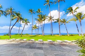 Ein Resort mit Poolbereich, Palmen und Blick auf den Ozean.
