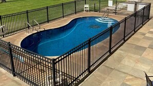 A swimming pool with a black fence, surrounded by palm trees and a view of the ocean. - Kihei Beach Stay at Hale Kai O' Kihei - Oceanfront in Maui (Kihei)
