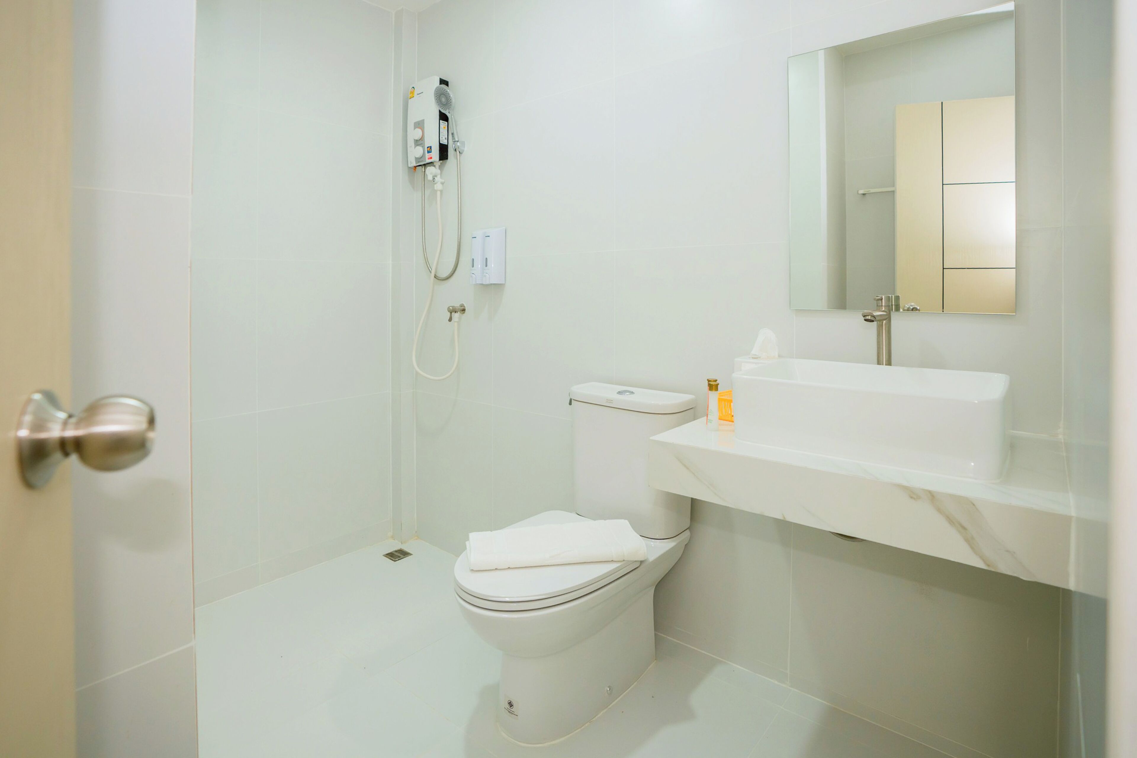 A modern bathroom with a toilet, shower, and sink.