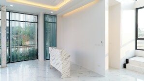 A modern interior with a marble table, large windows, and a clean, minimalist design. - Deluxe Hotel Chaiyaphum (Chatturat)