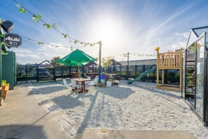 A children's play area with tables, chairs, and a slide. - Railway Hotel Winton (Winton)