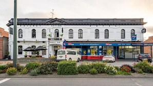 A historic building with a white facade, a railway sign, and a Middle Pub sign. - Railway Hotel Winton (Winton)