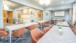 A conference room with tables, chairs, and a projector screen. - Railway Hotel Winton (Winton)