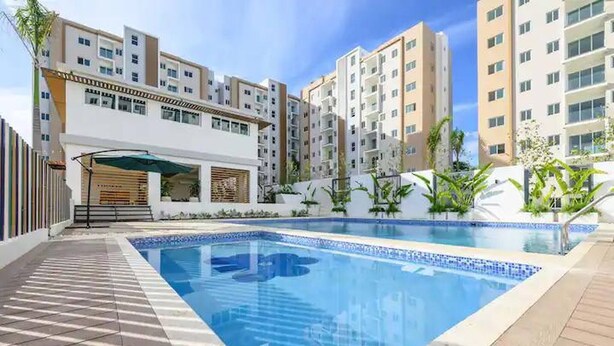 A swimming pool surrounded by multi-story residential buildings with balconies.