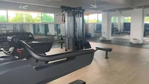 A gym with cardio equipment, weight machines, and benches.