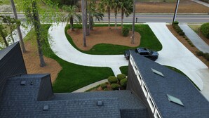 A residential area with a curved driveway, palm trees, and a black car parked on the street. - Beautiful Masters Rental, 3 Miles from Augusta National Golf Course (Augusta)