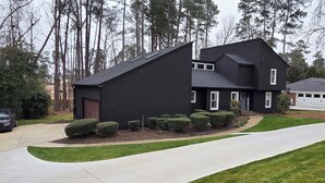 A modern two-story house with a dark exterior, a garage, and a driveway leading to the entrance. - Beautiful Masters Rental, 3 Miles from Augusta National Golf Course (Augusta)