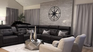 A modern living room with a sectional sofa, a coffee table, and a grey armchair. - Beautiful Masters Rental, 3 Miles from Augusta National Golf Course (Augusta)