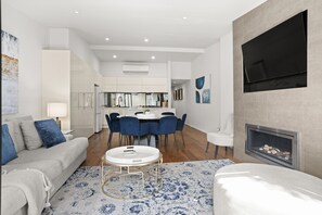 Ein modernes Wohnzimmer mit einer Couch, einem Couchtisch und einem Kamin.