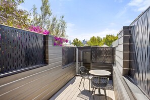 A rooftop terrace with a wooden deck, metal chairs, and a table. - Albertine House Pet Friendly Beachside Retreat (Albert Park)