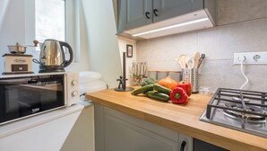 Una cocina con estufa, horno y varios utensilios.