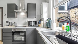 Una cuina moderna amb electrodomèstics integrats, un gran finestral i vistes a l'exterior.