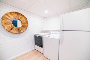 Une cuisine compacte équipée d’un lave-linge, d’un sèche-linge et d’un réfrigérateur.
