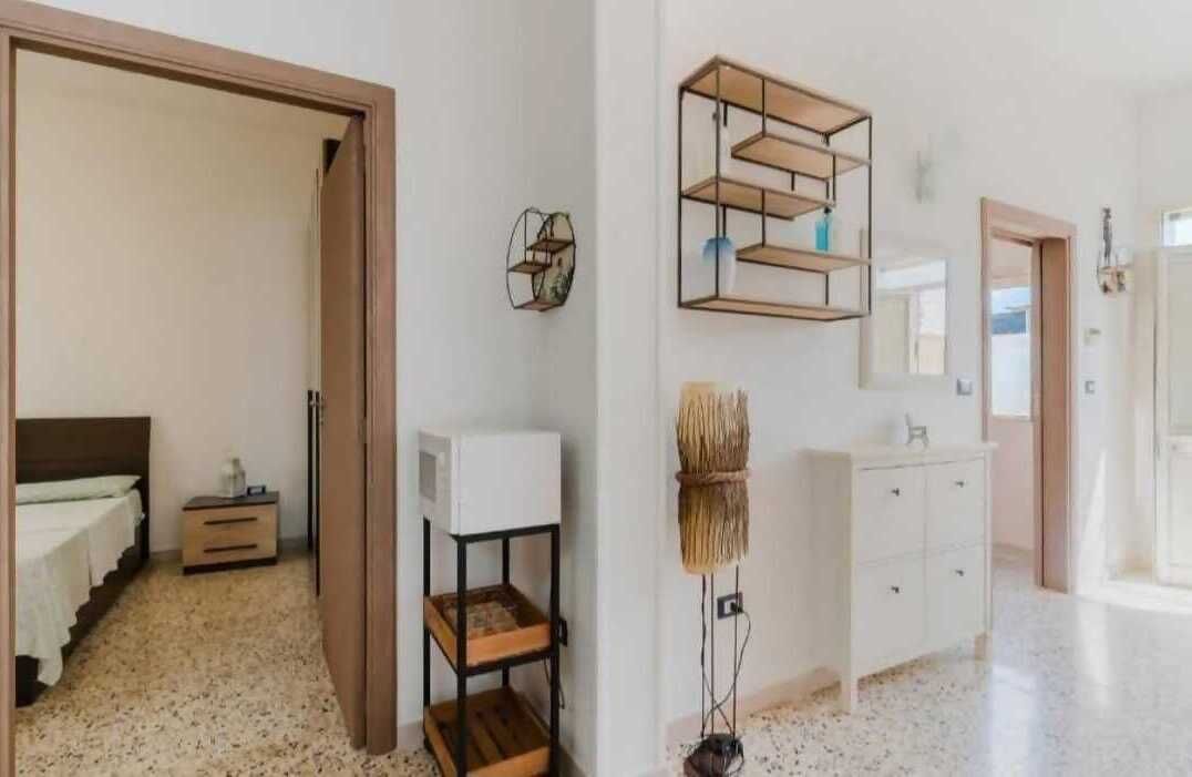 Une chambre d’hôtel comprenant un lit, une table de chevet et une étagère fixée au mur.
