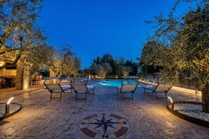A poolside area with lounge chairs, a compass design on the ground, and a pool in the background. - Residenza Lugana Pool & Garden in Peschiera Apt 1, Peschiera del Garda, Italy (Peschiera del Garda)
