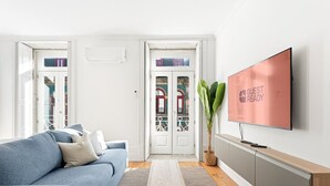 Una sala de estar moderna con un sofá, una mesa de centro, un televisor y una planta.