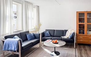 Un salon avec un canapé, une table basse et un meuble en bois.