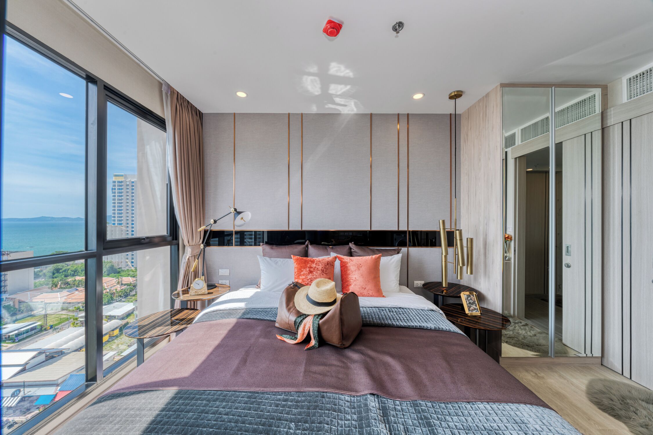 A modern hotel room with a large bed, a view of the city, and a balcony.