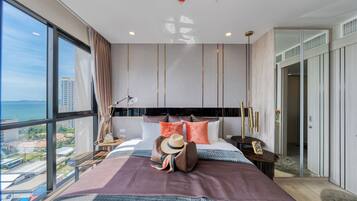 A modern hotel room with a large bed, a view of the city, and a balcony.