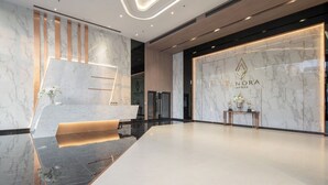 A modern lobby with a reception desk, marble walls, and a clean, minimalist design. - The Panora Pattaya by PH (Pattaya)