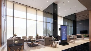 A modern lobby with seating areas, a large digital display, and large windows. - The Panora Pattaya by PH (Pattaya)