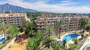 Un complexe hôtelier comprenant des bâtiments à plusieurs étages, une piscine et des palmiers.