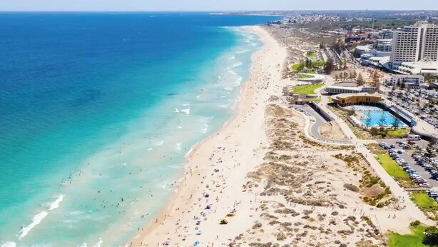 An aerial view of a coastal area with a beach, a swimming pool, and surrounding buildings. - Modern coastal stay in the heart of Scarborough (Scarborough)
