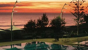 An outdoor swimming pool with a sunset view, surrounded by trees and street lamps. - Modern coastal stay in the heart of Scarborough (Scarborough)