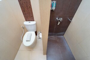 Uma casa de banho pequena com casa de banho, chuveiro e um porta-toalhas.