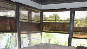 Ein überdachter Außenbereich mit einer Eckcouch, einem Couchtisch und einem Deckenventilator.