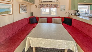 Een kamer met een rode bank, een tafel en een raam met uitzicht.