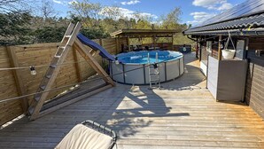 A wooden deck with a hot tub, a slide, and a covered seating area. - Beautiful home in Strängnäs with sauna (Strängnäs)