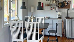 A kitchen with white cabinetry, a dining table with chairs, pendant lights, and a coffee maker. - Beautiful home in Strängnäs with sauna (Strängnäs)