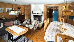 Une pièce chaleureuse avec une cheminée, des meubles en bois et une table à manger.