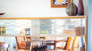 A glass-top table with wine glasses and a decorative vase. - Perfect 3-bed Higgins Surf Shack@the park by the Point in enchanting Middleton (Middleton)