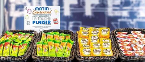 Exhibición de alimentos envasados en cestas, un cartel con texto y una ventana con fondo desenfocado.