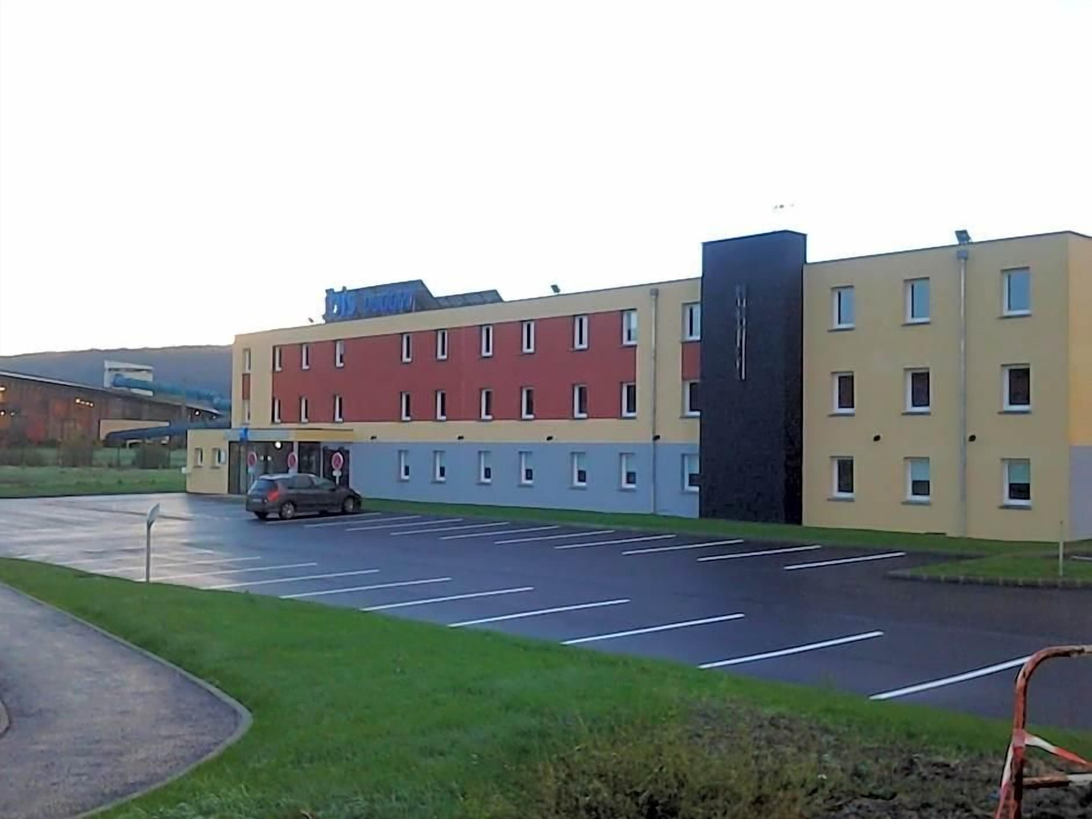 A multi-story building with a parking lot in front.