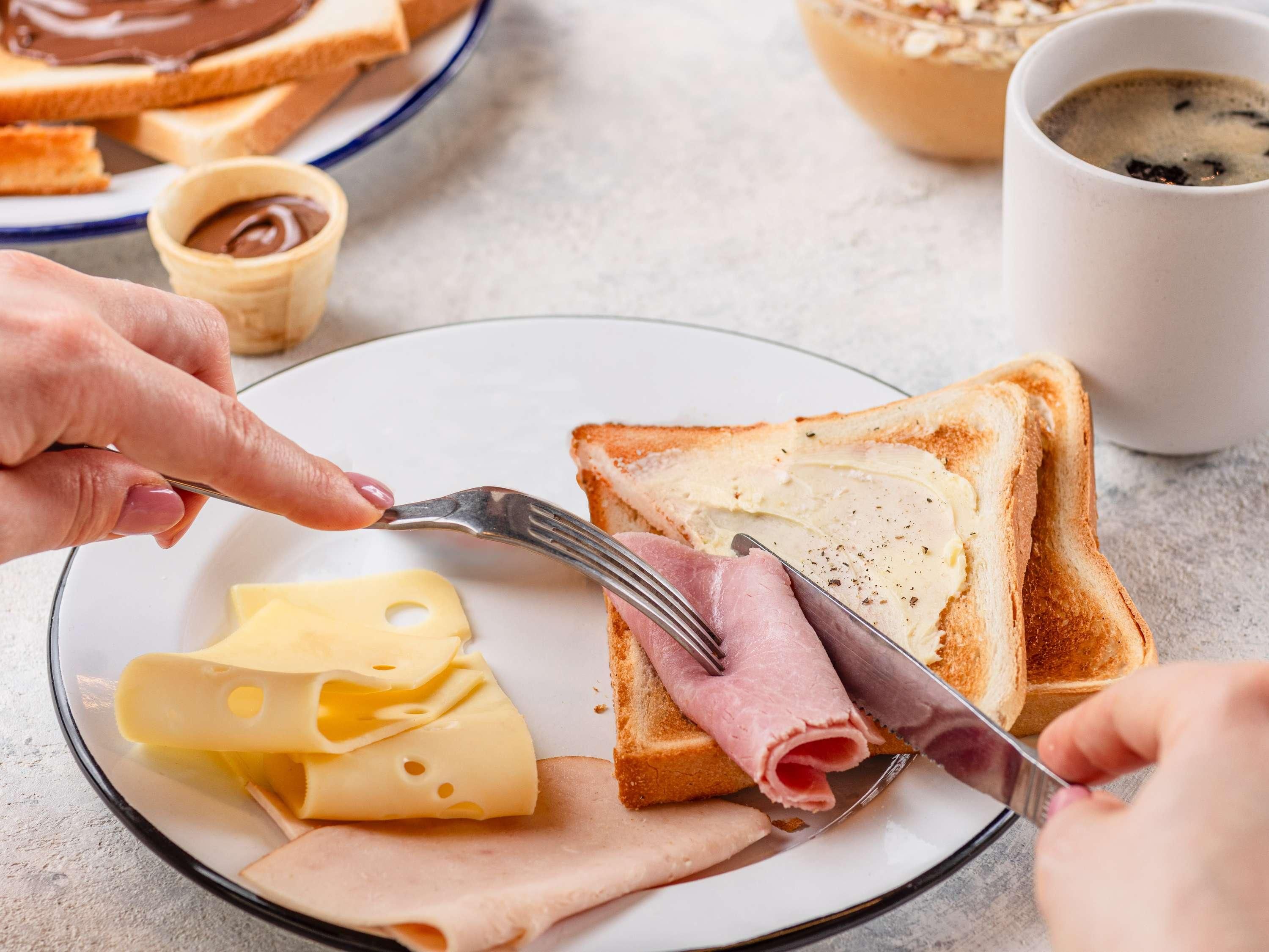 Une assiette avec des toasts, du fromage et du jambon.