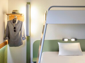 A bunk bed with a pillow and a hanging garment rack with a hat and a shirt. - Ibis Budget Givet (Givet)