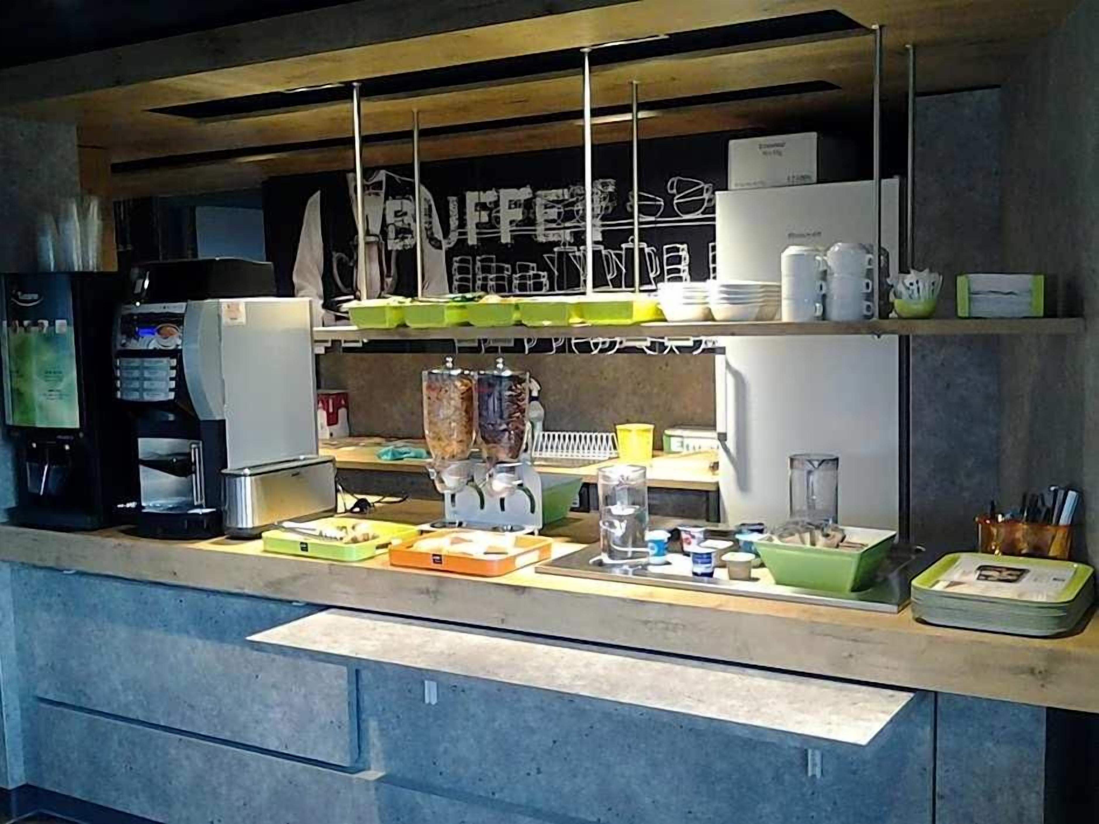 A kitchen area with a coffee machine, a blender, and various kitchen utensils on the counter.