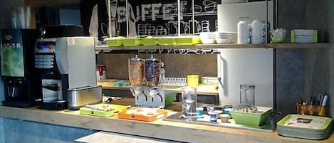 A kitchen area with a coffee machine, a blender, and various kitchen utensils on the counter.