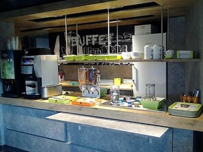 A kitchen area with a coffee machine, a blender, and various kitchen utensils on the counter. - Ibis Budget Givet (Givet)