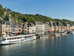Eine Stadt am Wasser mit historischen Gebäuden, einem Fluss und einem Boot, das an der Anlegestelle liegt.