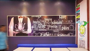 L’intérieur d’un restaurant, avec un mur décoré de mots liés à la nourriture et du logo Planet 21.