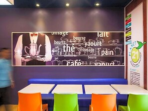 Ein Restaurantinneres mit einer Wandtafel, die lebensmittelbezogene Wörter und ein Planet 21 Logo zeigt.