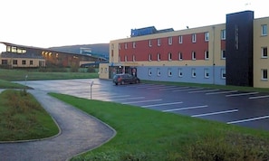 Un parking avec un bâtiment en arrière-plan.